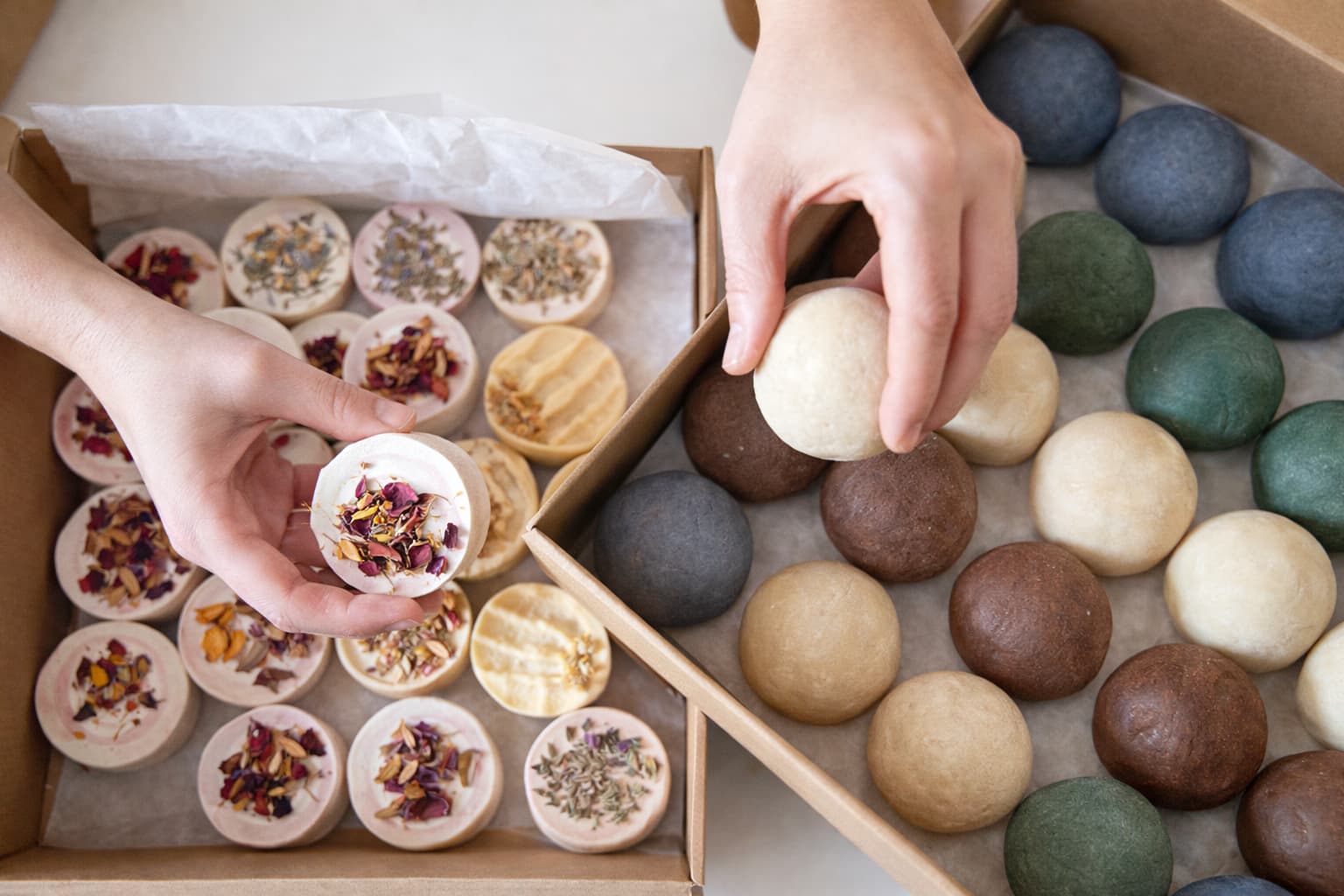 Handgemachte Naturseifen mit getrockneten Blüten werden in Kartons verpackt – Seife herstellen und verkaufen