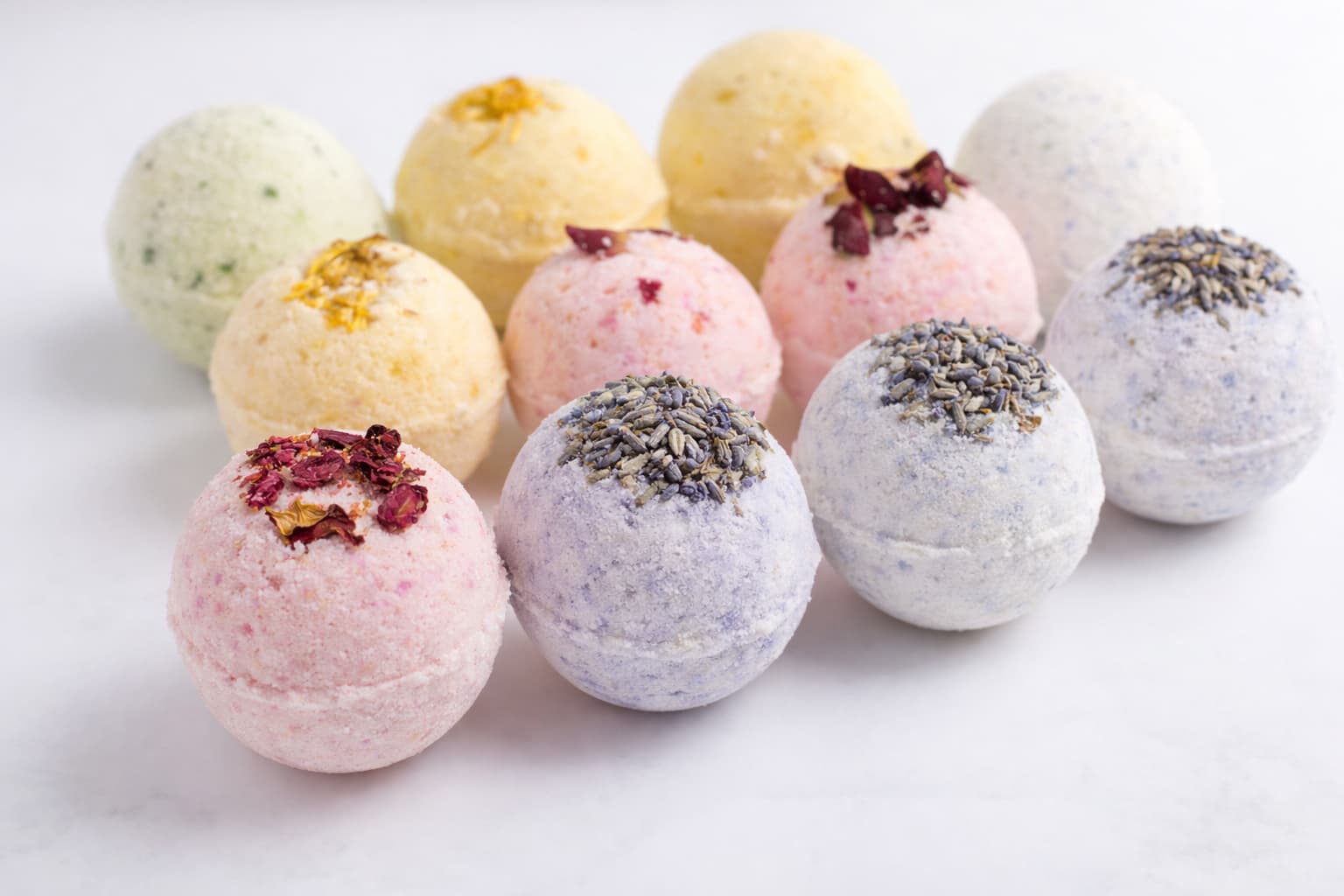 Colourful handmade bath bombs with lavender and rose petals — starter products for your cosmetics business